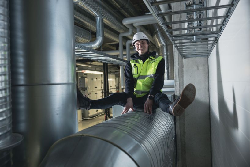 elvak huoltomies putken päällä istumassa